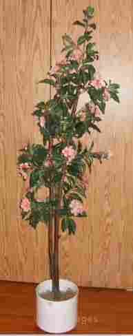 Beautiful artificial house plant with pink flowers